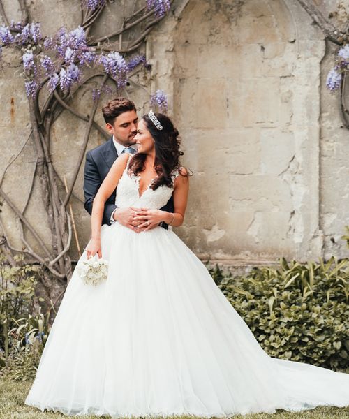 Bride in Pronovias princess wedding dress with groom in front of Kirtlington Park House wedding venue. 