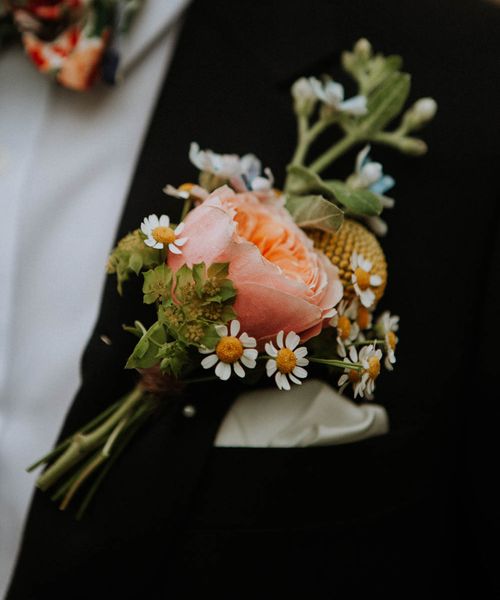 Roundup of stylish groom buttonholes with fresh and dried flowers, foliage, feathers and pins.