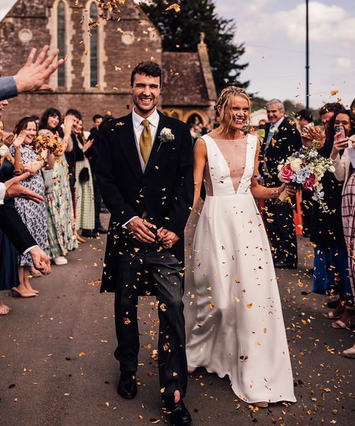 Bride walking with the groom out to confetti in a Andrea Hawkes wedding dress.