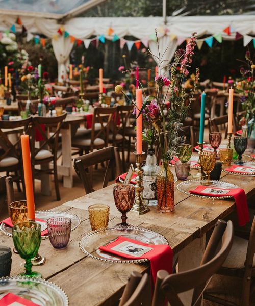 Clear marquee wedding reception in a back garden with colourful flower and table decor 