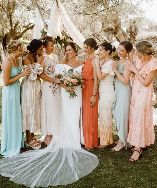 Bride with her bridesmaids in mismatched bridesmaid dresses for destination wedding.