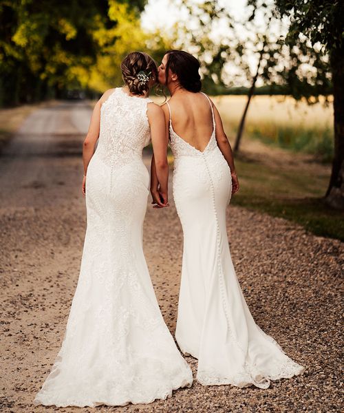 Brides in lace wedding dresses for outdoor summer wedding at Cripps Barn.