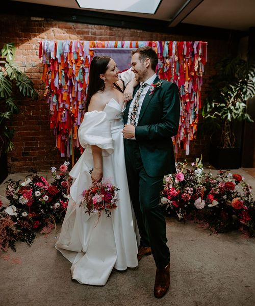 DIY rainbow streamers altar decoration with bride and groom