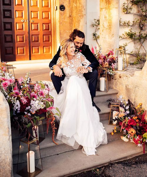 Bride in a Margaux Tardits wedding dress laughing with groom at their Elmore Court wedding.