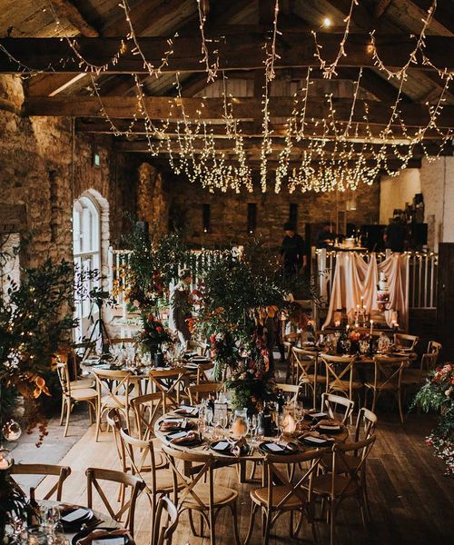 Autumn theme wedding at Askham Hall in cumbria with fairy lights and tree centrepieces 