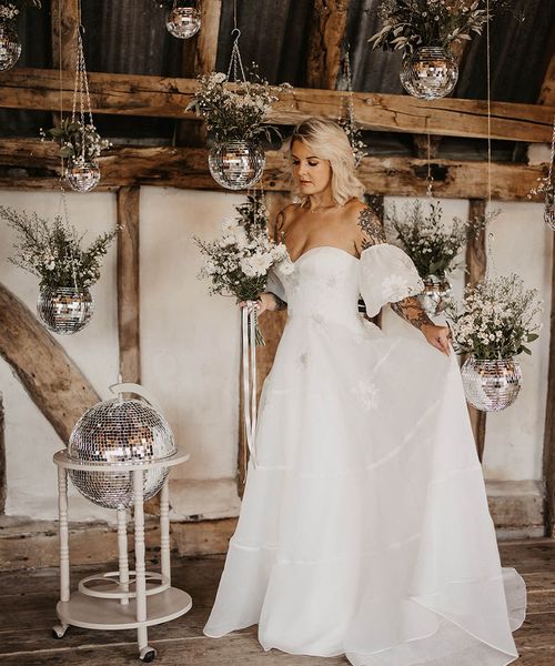 bride at disco wedding with disco ball decor