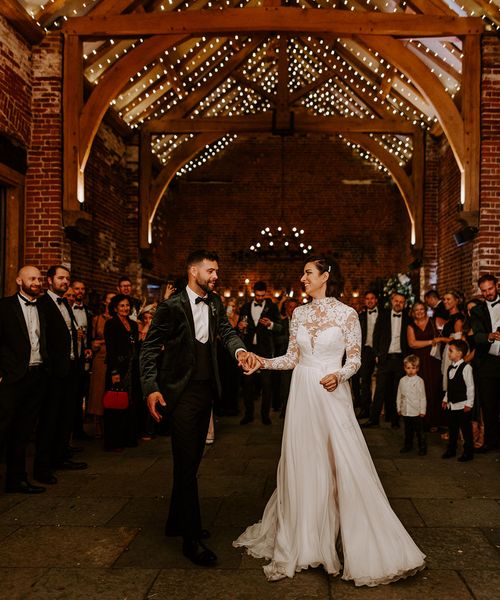 Bride and groom have their first dance with fairy-lights at rustic Hazel Gap Barn wedding venue. 