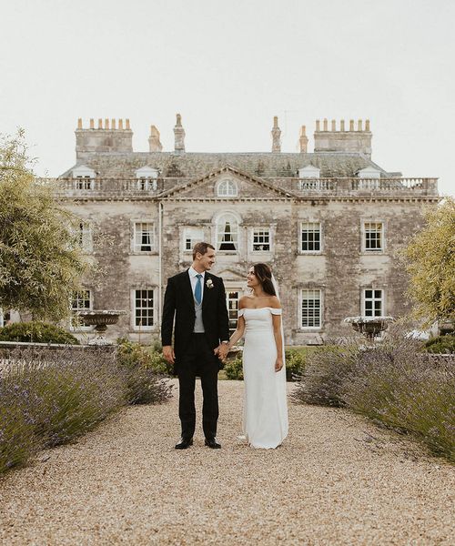 Bride and groom walking in front of Came House in Dorset.