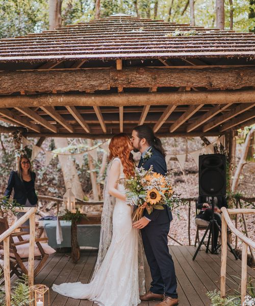 Outdoor forest wedding with sunflower wedding bouquet, embroidered veil and lace wedding dress.