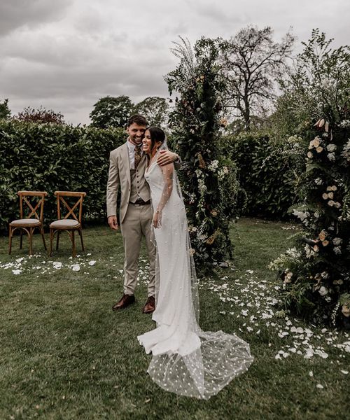 Indian and English multicultural garden wedding with a clear marquee and a bride in a slip wedding dress and pearl veil by Epic Love Story