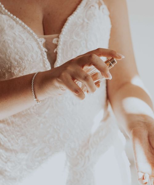 Bride Spraying Wedding Perfume on Wrist on Wedding Day 