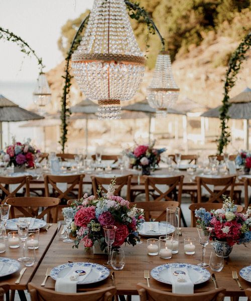 beach bar wedding in Greece with boho wedding dress and pink and blue wedding flowers 