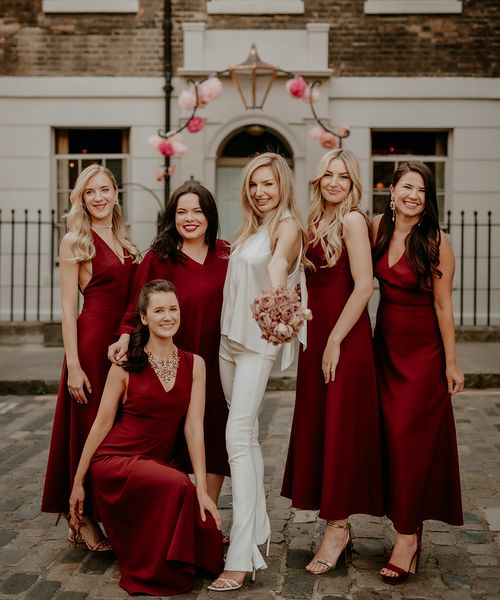 Bride with bridesmaids in dark red bridesmaid dresses for townhouse wedding.