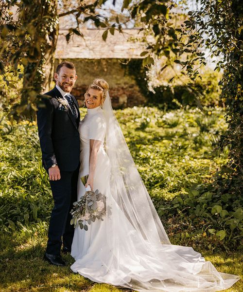 Launcells Barton wedding with bride in high neck wedding dress and groom.