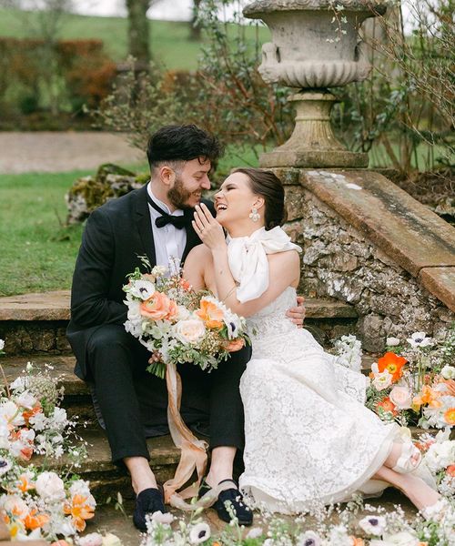 Romantic Holesfoot wedding inspiration with orange and white flowers, lace and beaded wedding dresses and an iced wedding cake