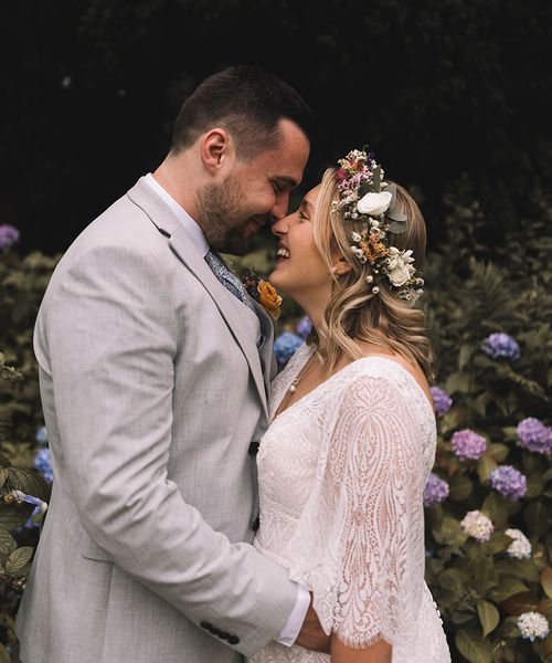 Bride wearing a wildflower wedding crown with groom at boho wedding.