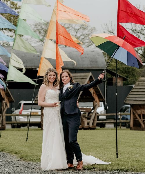 LGBTQIA+ Stanford Farm Pride wedding with rainbow festival flags, fairy lights and foliage weddng decor by The Bearded Man Photography