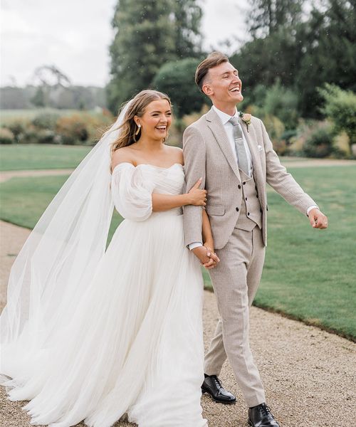 Bride in whimsical wedding dress with the groom for country house wedding.