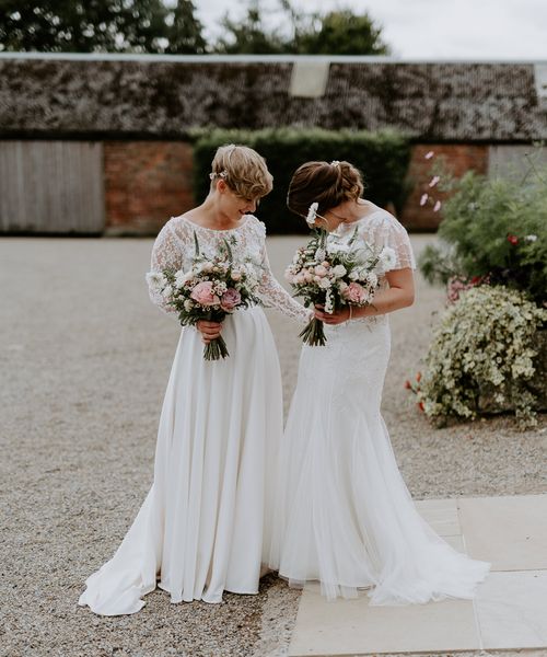 Lesbian couple at Woolas barn wedding with lace and embellished wedding dresses 