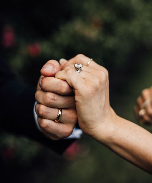 bride-and-groom-holding-hands-with-wedding-bands