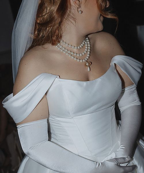 layered pearl wedding necklace, paired with an off-shoulder corset-style wedding dress