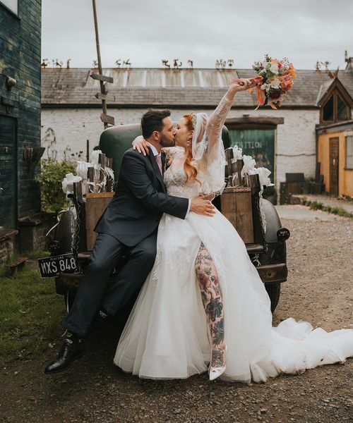 bride-and-groom-kiss-in-front-of-wedding-car-at-welsh-wedding