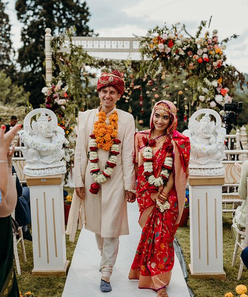 bride-and-groom-walking-back-down-the-aisle-at-hindu-wedding-ceremony-at-plas-dinam