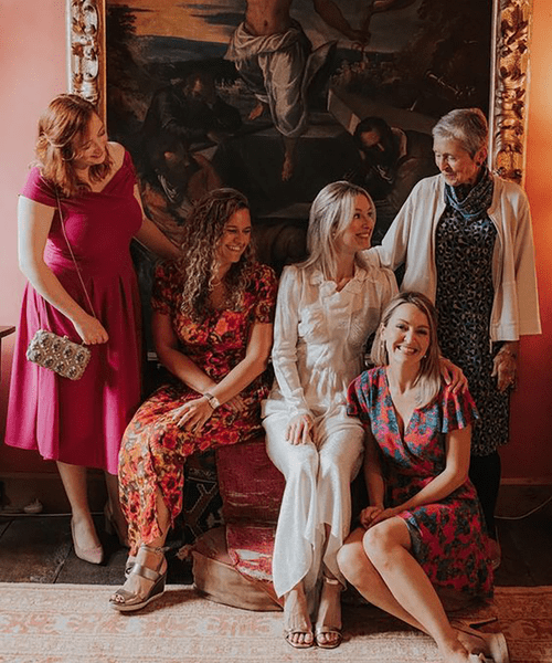 guests wearing casual wedding attire, including pink midi dresses and floral jumpsuits