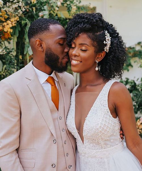 A bride with beautiful afro-kinky hair, styled with a delicate silver wedding hair accessory.