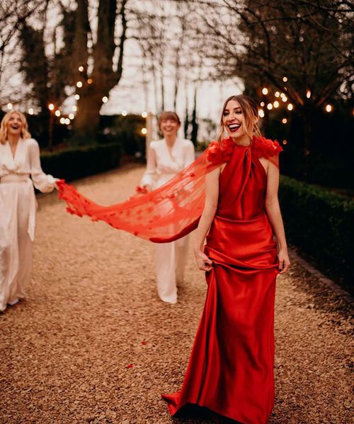 Bride in satin layered neckline red wedding dress with cape