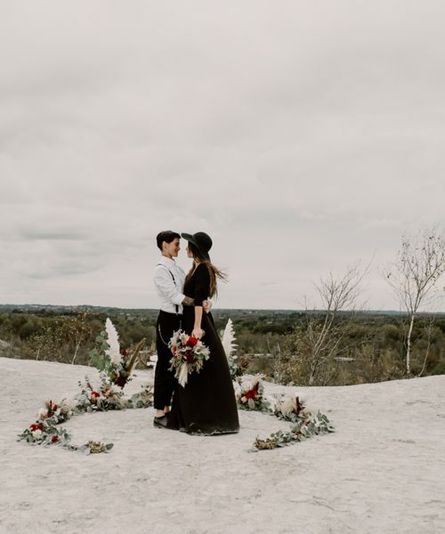 Black Wedding Dress for Wild Same-Sex Couple Wedding Inspiration | Pampas Grass, Eucalyptus & Red Rose Horseshoe Floral Design | Anne Letournel Photography