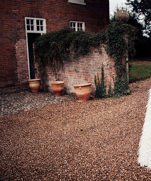 Charlie Brear Payton Bridal Gown & Piora Feather Skirt with Deep Red, Grasses & Pheasant Feather Floral Installation at Iscoyd Park, shot by Harry Michael