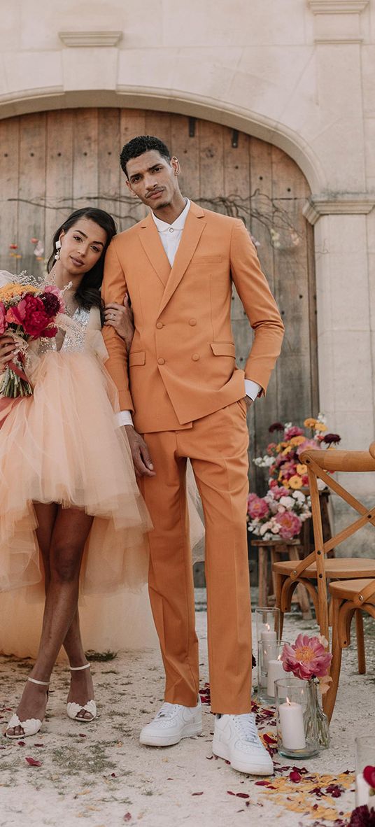 Orange wedding theme with the bride and groom in orange wedding outfits.