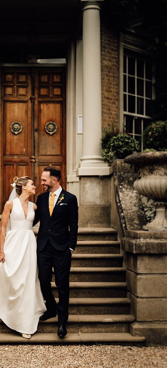 Hampton Court House wedding in Surrey with bride and groom posing together.