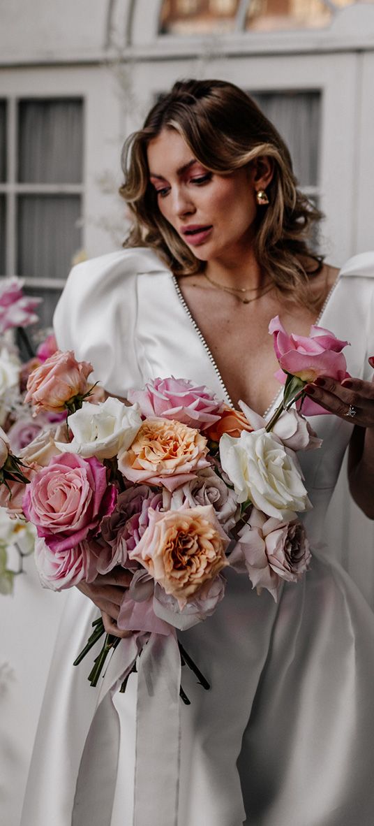 Bride holding a colourful pink and white rose wedding bouquets 