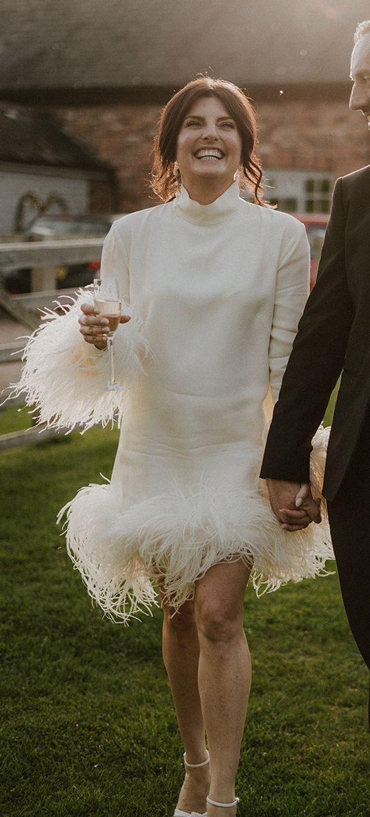 Larkspur Lodge wedding with bride wearing a short feather wedding dress with groom in black tuxedo