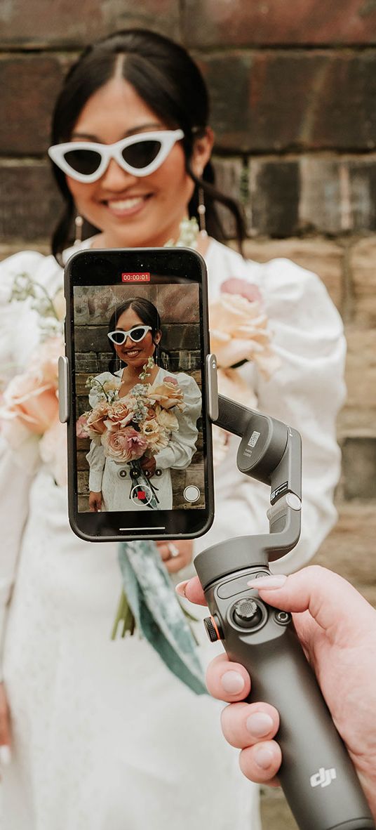 Wedding content creator filming bride with retro sunglasses on