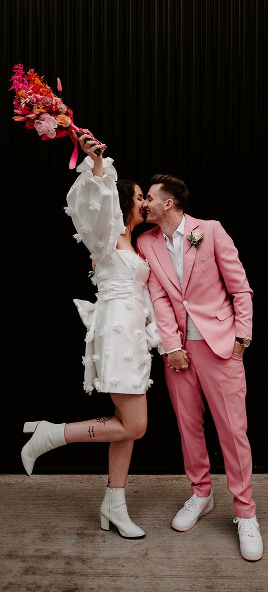 bride in short wedding dress with groom in pink suit at pink retro disco theme wedding