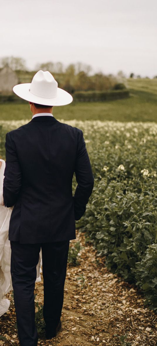 Country theme Stone Barn wedding with bride and groom wearing cowboy hats