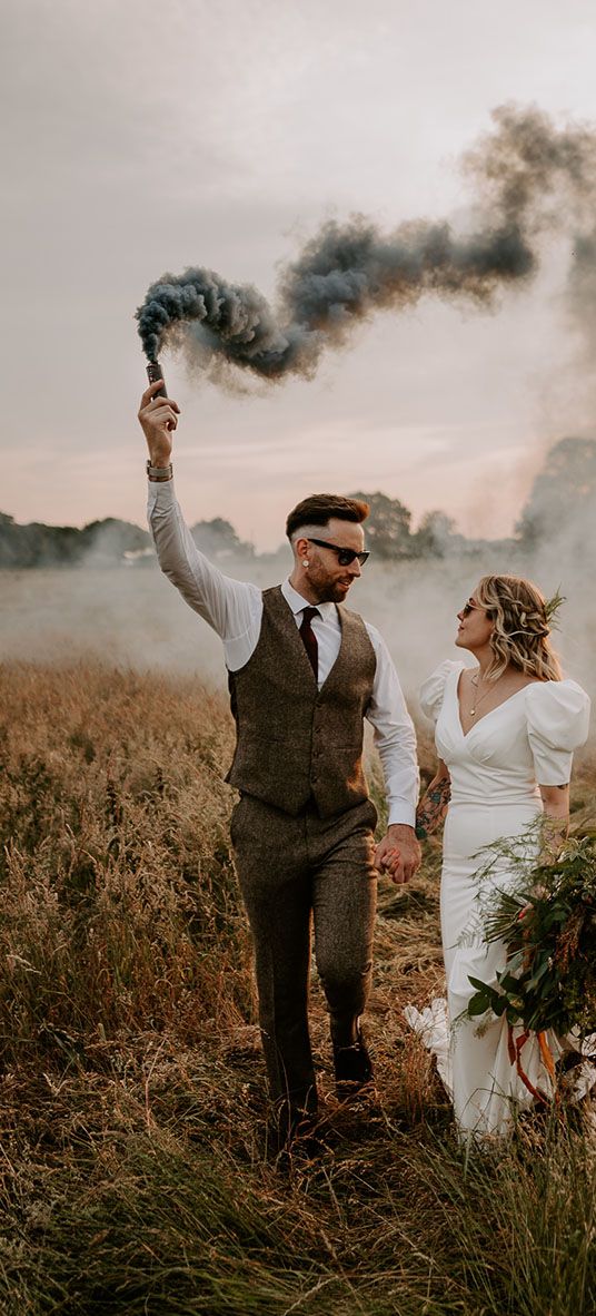 Willow Marsh Farm wedding with the bride and groom waving smoke bombs