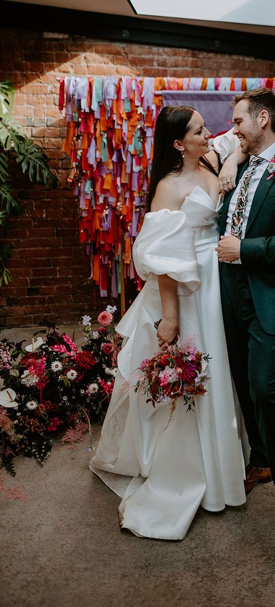 DIY rainbow streamers altar decoration with bride and groom