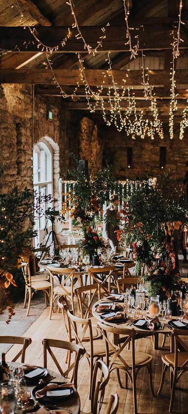 Autumn theme wedding at Askham Hall in cumbria with fairy lights and tree centrepieces 