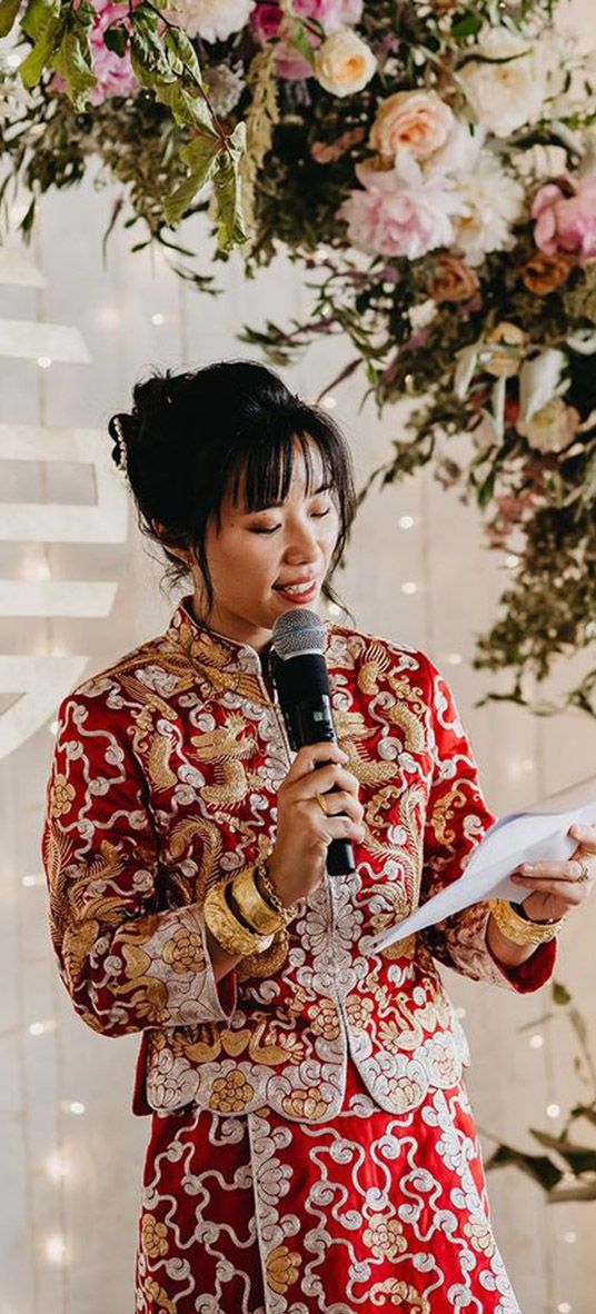 Bride in Chinese wedding attire reading out modern wedding reading