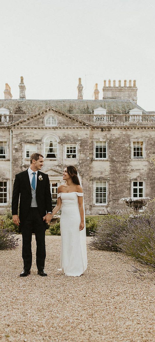 Bride and groom walking in front of Came House in Dorset.