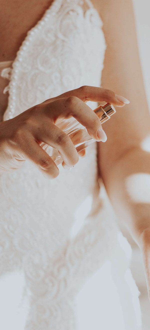 Bride Spraying Wedding Perfume on Wrist on Wedding Day 