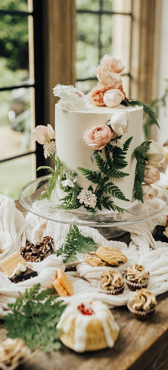 Vegan wedding inspiration with a dessert table and white iced wedding cake.