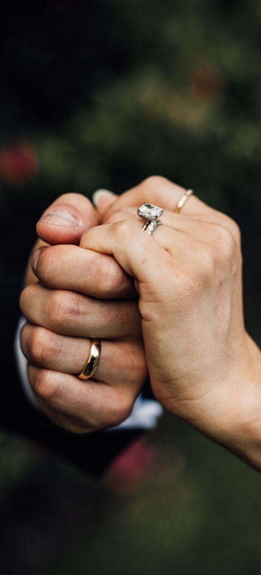 bride-and-groom-holding-hands-with-wedding-bands