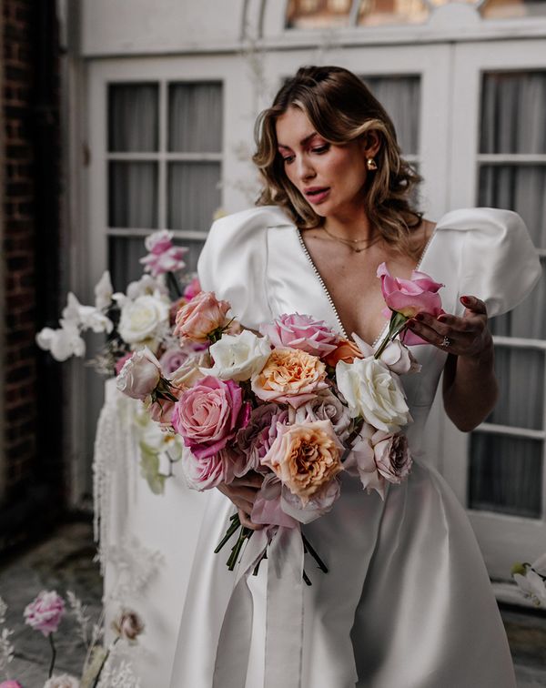 Bride holding a colourful pink and white rose wedding bouquets