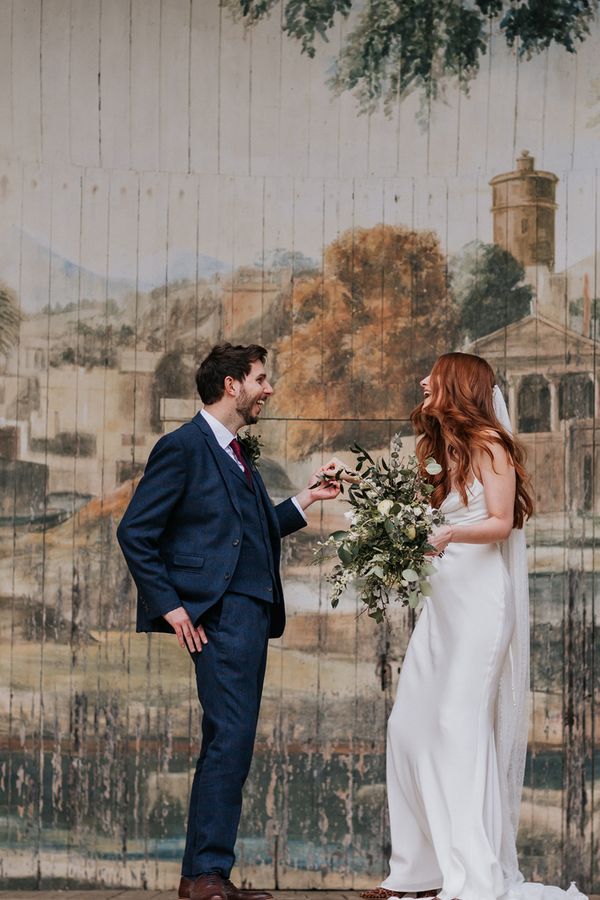 Intimate Larmer Tree wedding with the bride in a satin slip wedding dress and long veil with a green and white bridal bouquet.