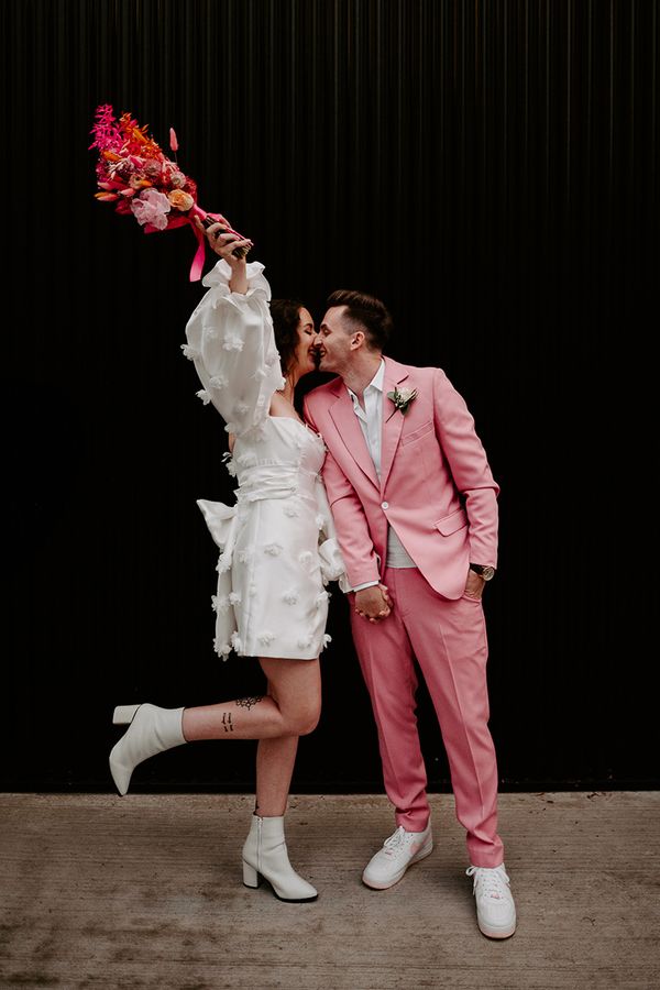 bride in short wedding dress with groom in pink suit at pink retro disco theme wedding